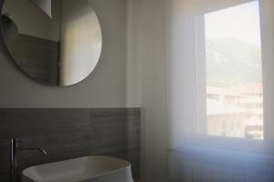a bathroom with a mirror and a sink and a window at Fortuna's quiet place in Riva del Garda +36 photos