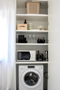 a laundry room with a washer and a microwave at Fortuna's quiet place in Riva del Garda