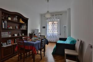 a living room with a table with chairs and a couch at Ai Bastioni del Massimo in Palermo