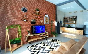 sala de estar con pared de ladrillo y TV en Villa FELIA - 5 Kamar Tidur, 3 Kamar Mandi, Luas, en Batu