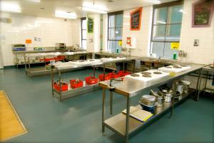 a large kitchen with several tables in a room at Flinders Backpackers in Melbourne