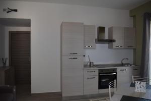 cocina con armarios blancos y fogones en Eclisse House - close to the beach, en Villaggio San Leonardo