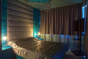 1 dormitorio con cama y lámpara de araña en Madison, en Atenas