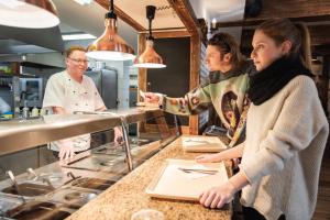 a group of people standing in a kitchen at Hotel Rankl in Horská Kvilda