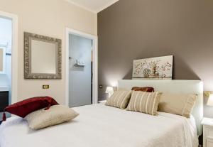 a white bedroom with a large white bed and a mirror at Saint Philippe Maison in Aci Catena