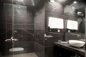 Baño negro con lavabo y espejo en Madison, en Atenas