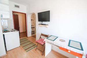a small room with a small table and a kitchen at Apartments Milena in Tivat