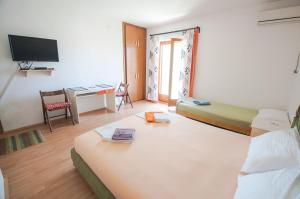 a hotel room with two beds and a desk at Apartments Milena in Tivat