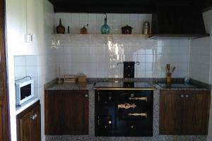 a kitchen with a black stove and a microwave at A Minguxaina in Ribadeo