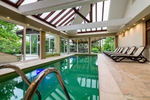 una piscina cubierta con un salón acristalado con ventanas en Edenrock Stairs en Leányfalu