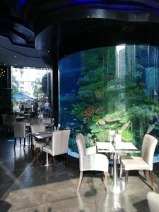 a restaurant with a large aquarium and tables and chairs at Centara Avenue apartment 711 in Pattaya