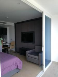 a bedroom with a bed and a couch and a tv at Centara Avenue apartment 711 in Pattaya