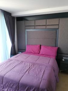 a purple bed with pink pillows in a bedroom at Centara Avenue apartment 711 in Pattaya