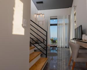 a living room with a staircase and a television at Tramonto Suites in Xi