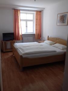 Un dormitorio con una cama grande y una ventana en Altstadtpension, en Burghausen