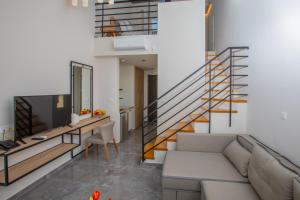 a living room with a couch and a staircase at Tramonto Suites in Xi