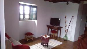 a living room with a couch and a piano at A Minguxaina in Ribadeo