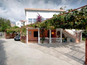 a house with a car parked in front of it at Apartments Ruza in Budva