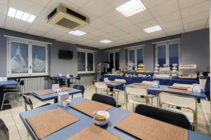 a dining room with blue tables and chairs at Twelve Hotel in Moncalieri