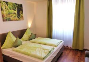 ein Schlafzimmer mit einem Bett mit Kissen und einem Fenster in der Unterkunft Ferienwohnung 14 - Sofia Haus Hühnergott in Ostseebad Sellin