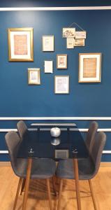 stół z krzesłami i niebieska ściana z obrazami w obiekcie Afonso Galo Guest Apartments I w mieście Almada