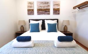 阿爾馬達的住宿－Afonso Galo Guest Apartments I，一间卧室配有一张带蓝色和白色枕头的床