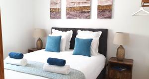 a bedroom with a bed with blue and white pillows at Afonso Galo Guest Apartments I in Almada