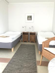 um quarto com 2 camas, uma mesa e um tapete em Hillesgården em Boarp