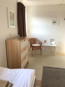 a bedroom with a dresser and a chair and a table at Hillesgården in Boarp