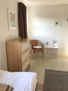 um quarto com uma cómoda, uma cadeira e uma mesa em Hillesgården em Boarp