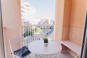 Biały stół i krzesła na balkonie w obiekcie Mediterráneo Vela w mieście Benicàssim
