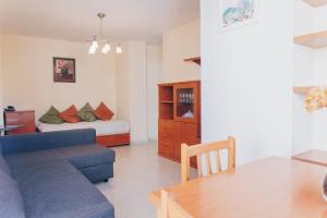 salon z niebieską kanapą i łóżkiem w obiekcie Mediterráneo Vela w mieście Benicàssim