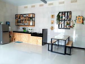 バトゥにあるVilla FELIA - 5 Kamar Tidur, 3 Kamar Mandi, Luasのガラスのテーブルと冷蔵庫のあるキッチン