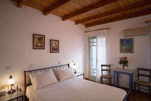 a bedroom with a white bed and a window at Nostos Hotel in Chania Town
