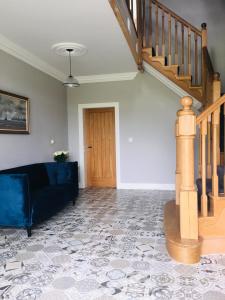 a living room with a couch and a staircase at Ferney House in Irvinestown