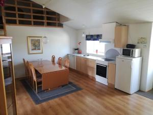 a kitchen with a table and a white refrigerator at Bindesbølgård Farm Holiday in Give