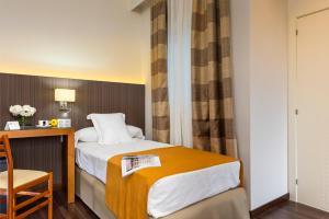 a hotel room with a bed and a chair at Hotel de Francia y París in Cádiz