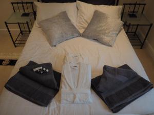 een bed met handdoeken en kussens erop bij Hazeldene Cottage in Holmfirth