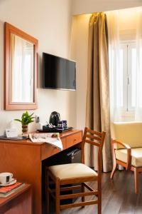 a hotel room with a desk and a chair at Hotel de Francia y París in Cádiz