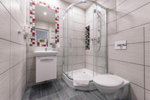 a bathroom with a toilet and a sink and a shower at Rembrandt Aparthotel in Kraków