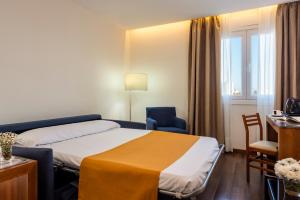 a hotel room with a bed and a table and chairs at Hotel de Francia y París in Cádiz