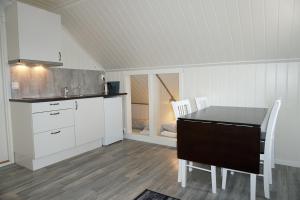 - une cuisine avec une table et des chaises dans la chambre dans l'établissement Varanger Fisherman's Shed, à Varangerbotn