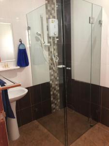 um chuveiro com uma porta de vidro na casa de banho em Pakham Gardens Resort em Prakham
