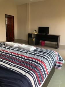 Pakham Gardens Resort في Prakham: غرفة نوم مع سرير كبير مع مكتب