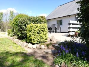 a garden with bushes and flowers in front of a house at Bindesbølgård Farm Holiday in Give