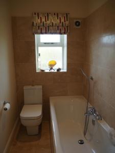 une salle de bain avec baignoire et toilettes et une fenêtre dans l'établissement Hazeldene Cottage, à Purmerend 30 autres photos