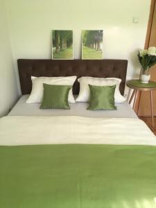 ein großes Bett mit grüner und weißer Bettwäsche und Kissen in der Unterkunft Apartment Green in Sarajevo