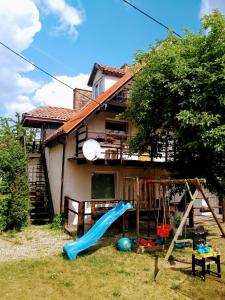 a house with a slide and a playground at Pensjonacik Gafel in Ruciane-Nida
