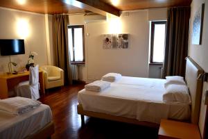 Habitación de hotel con 2 camas y TV en Hotel Pinamonte en Costermano