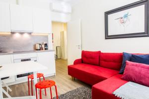 a living room with a red couch and a kitchen at Central 1BD Apartment by Hostlovers in Kaunas